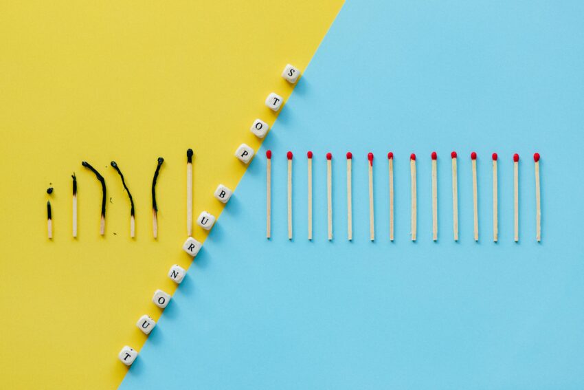 Illustration of burnout concept with burned matches and letter cubes spelling 'Stop Burnout.'
